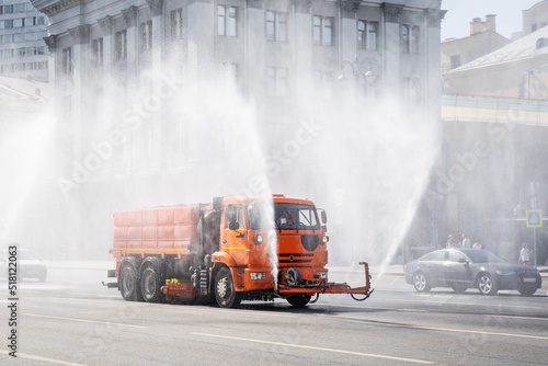Works machine for cleaning the streets. Spraying water to purify urban air. Moscow, Russia,
