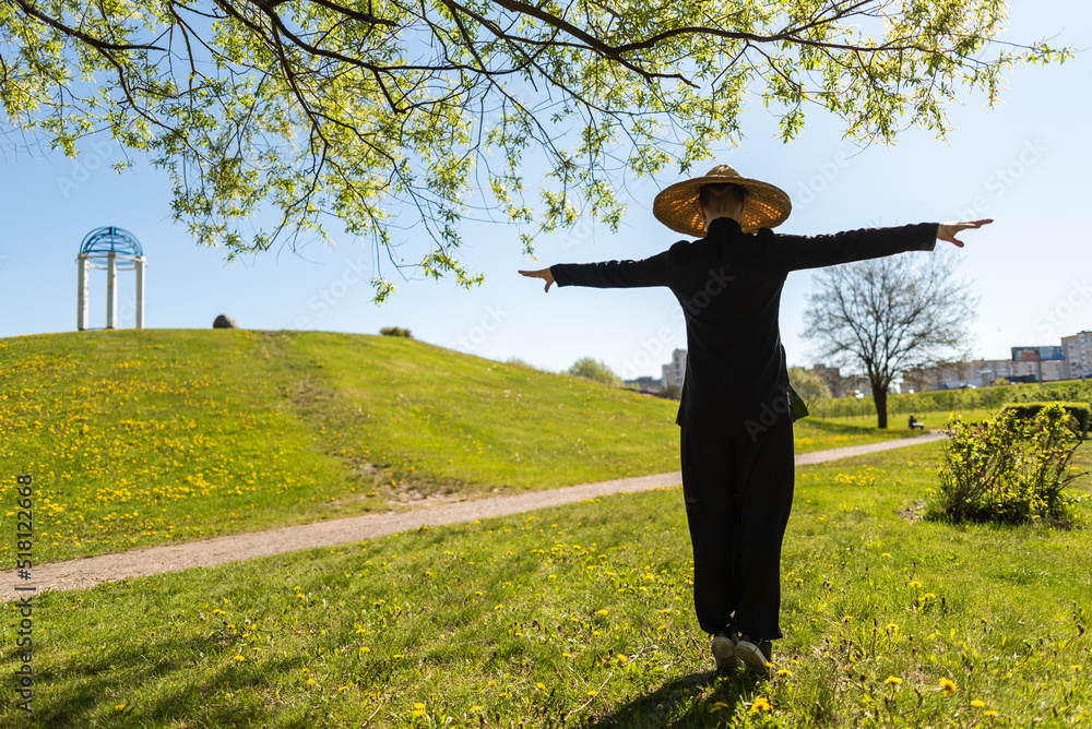 Asian woman with hat practicing taijiquan outdoors, chinese martial arts, healthy lifestyle concept. Asian woman with hat practicing taijiquan outdoors, chinese martial arts, healthy lifestyle concept.