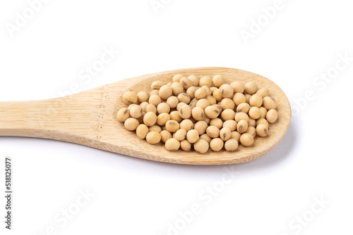 Uncooked soy beans in a spoon isolated over white background