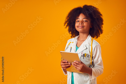 Foto Studio Portrait Of Boy Dressed As Doctor Or Surgeon With Digital Tablet Against