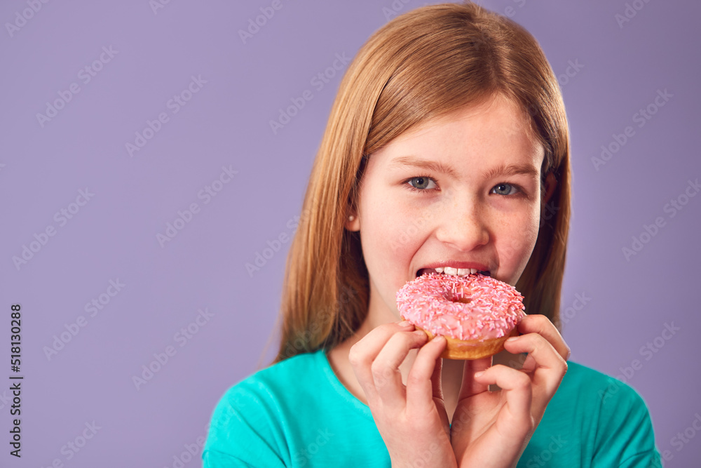 Studio Portrait Of Girl Eating Donut Against Purple Background Studio Portrait Of Girl Eating Donut Against Purple Background