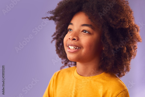 Studio Portrait Of Smiling Young Boy Shot Against Purple Background