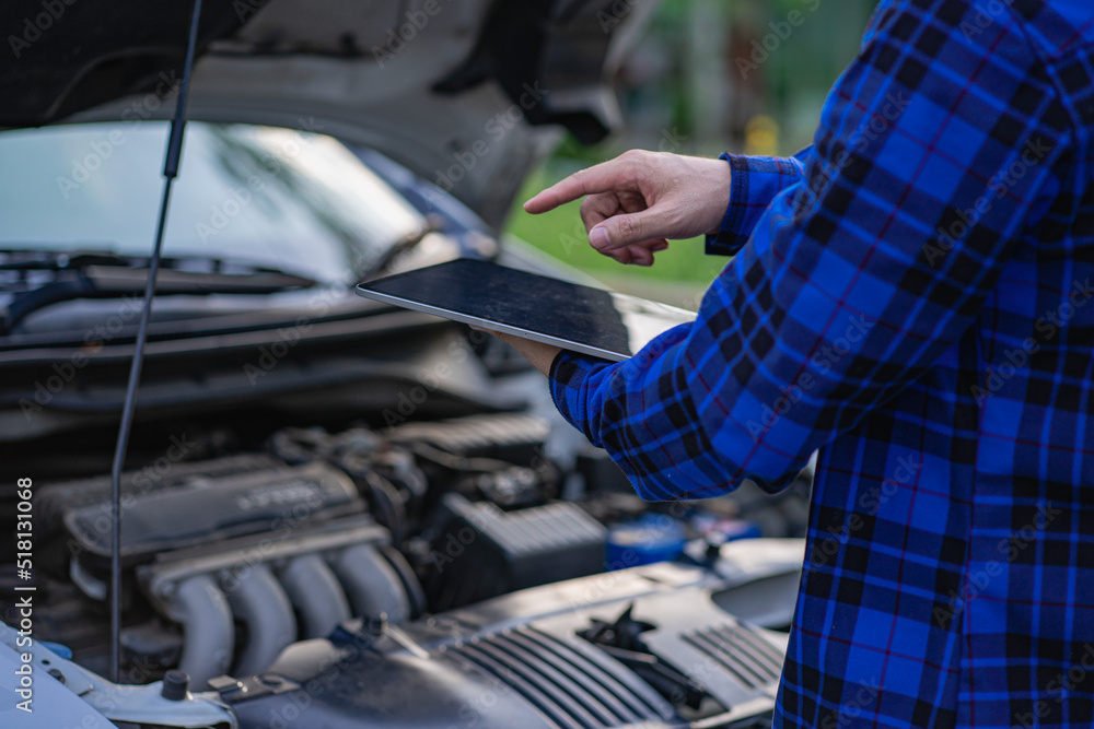 A young man checks his car and repairs it before going on a long journey. A young man checks his car and repairs it before going on a long journey.