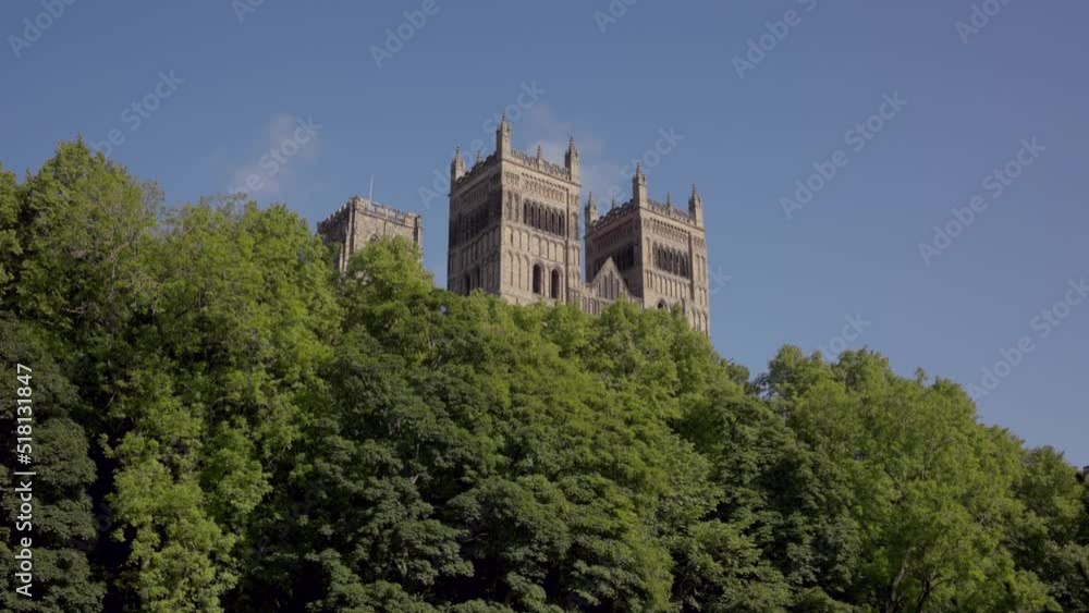 Durham England: 2022-06-07: Durham Cathedral during sunny summer day. View from the riverside with lots of lush green trees. Ungraded footage Durham England: 2022-06-07: Durham Cathedral during sunny summer day. View from the riverside with lots of lush green trees. Ungraded footage