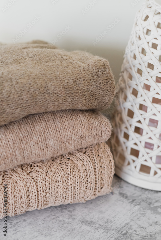 a stack of knitted beige things in close-up. the texture of a knitted sweater. autumn and winter cozy clothes