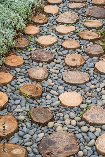 Walkway made of logs and pebbles in a landscaped garden