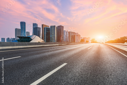Empty asphalt road and modern city skyline with buildings in Hangzhou at sunset  China.