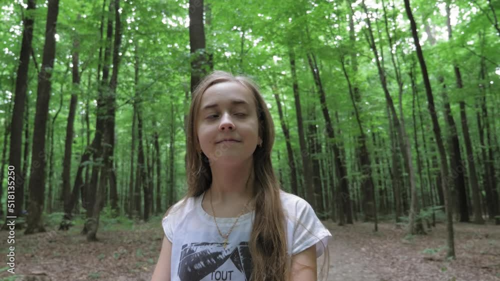 Portrait of a pretty girl walking alone in the forest. A teenager with long hair walks in the forest during the day. Portrait of a pretty girl walking alone in the forest. A teenager with long hair walks in the forest during the day.