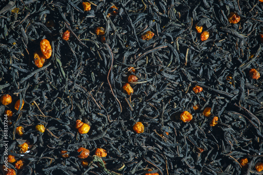 Green tea with berries background top view. Ivan tea with sea buckthorn background texture. Dried tea leaves and berries background. Fragrant tea is sprinkled with background. Chamerion angustifolium. Green tea with berries background top view. Ivan tea with sea buckthorn background texture. Dried tea leaves and berries background. Fragrant tea is sprinkled with background. Chamerion angustifolium.
