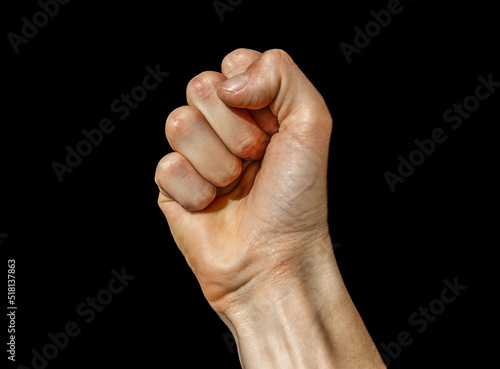 A man's palm is clenched into a fist isolated on a black background. Fist on black background. 