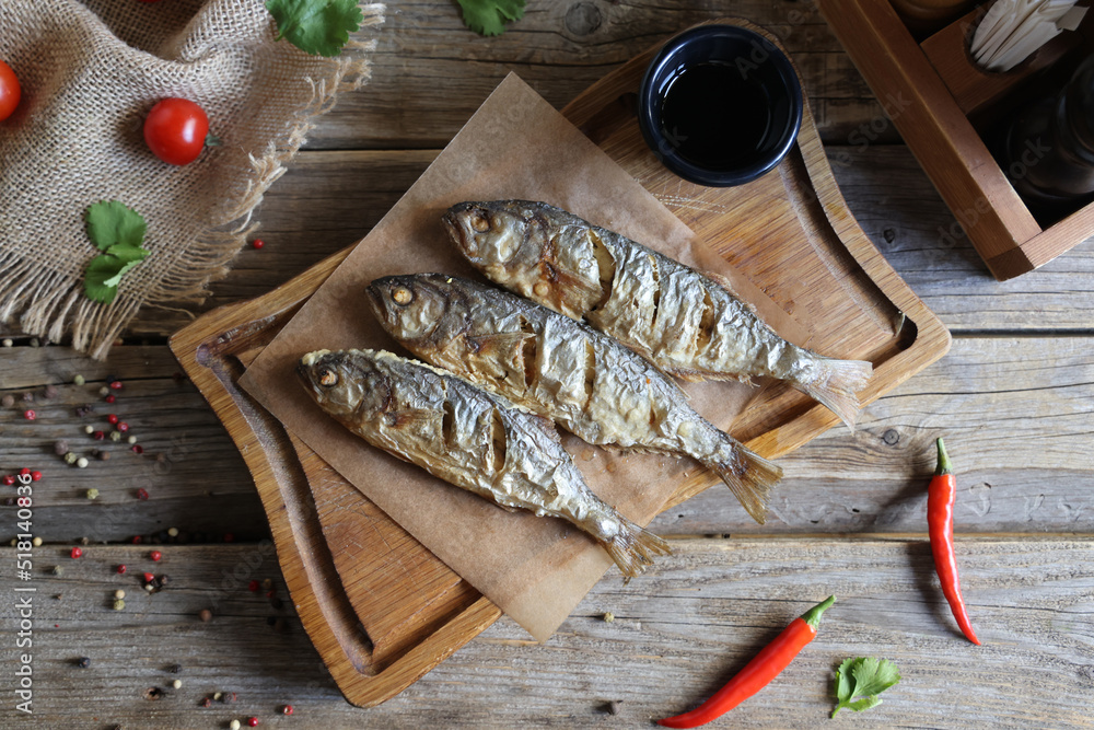 fried surmullet on board on old wooden table fried surmullet on board on old wooden table