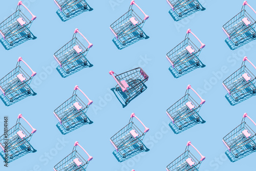 Pattern of supermarket shopping cart on pastel blue background. Creative design for packaging. Online shopping. Black friday sale concept. Break the pattern. Sustainable, minimalist lifestyle.