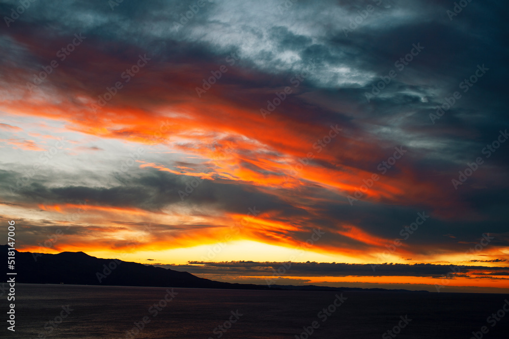 beautiful landscape on sea with sunset, dramatic clouds with red fire