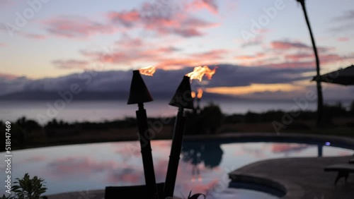 tiki torches bruning during a colorful sunset in maui hawaii photo