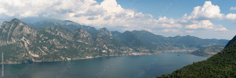 Panorama at Lake Iseo and mountains around at sunny day with clouds. Bergamo, Lombardy, Italy.
