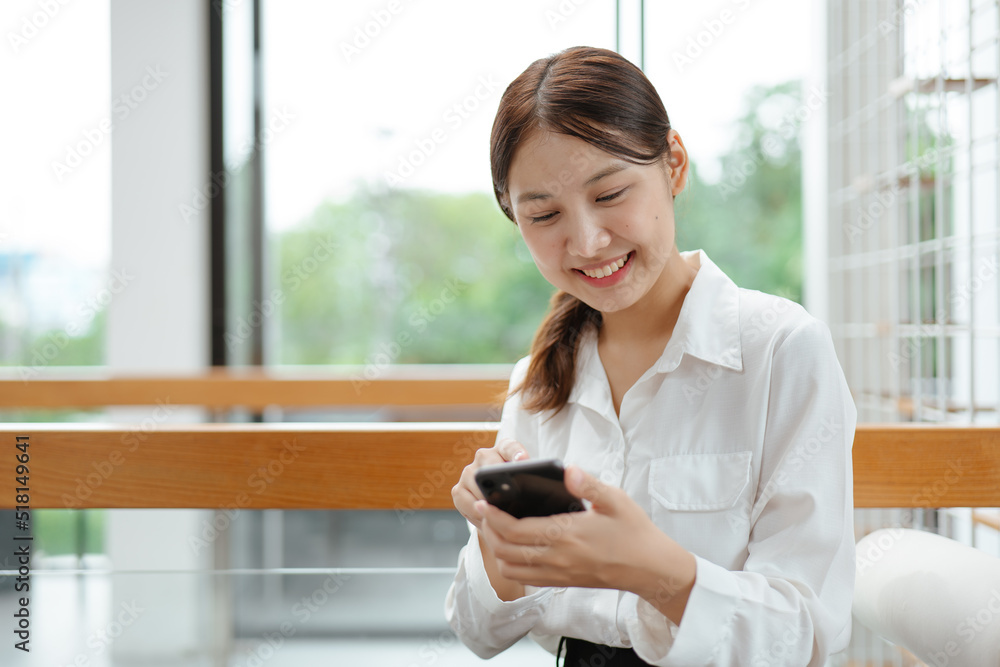 Fototapeta premium Business woman working on smartphone in office space.