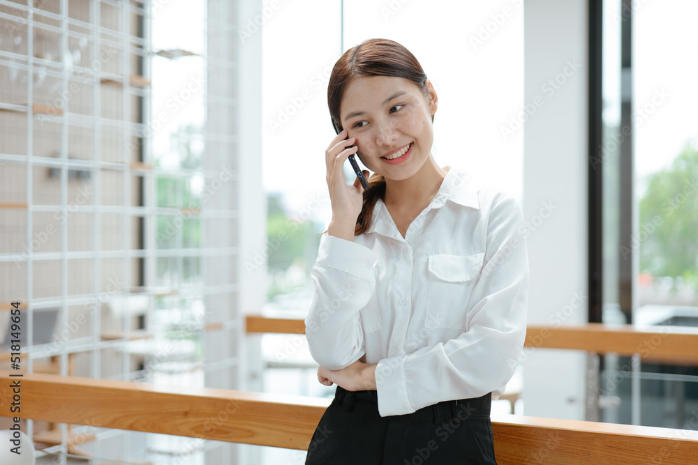 Young business woman discussing and talking with co-worker and client via smartphone with happy face. Young business woman discussing and talking with co-worker and client via smartphone with happy face.