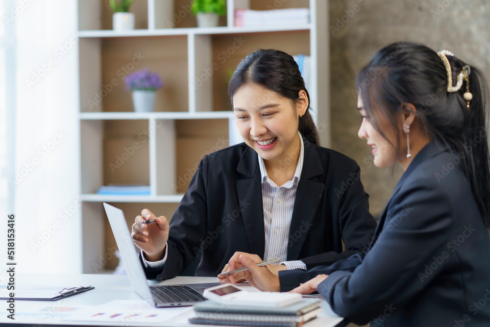 Two young Asian businesswomen discuss with new startup project Idea presentation, analyze planning and financial statistics and investment market on laptop computer at office. Two young Asian businesswomen discuss with new startup project Idea presentation, analyze planning and financial statistics and investment market on laptop computer at office.