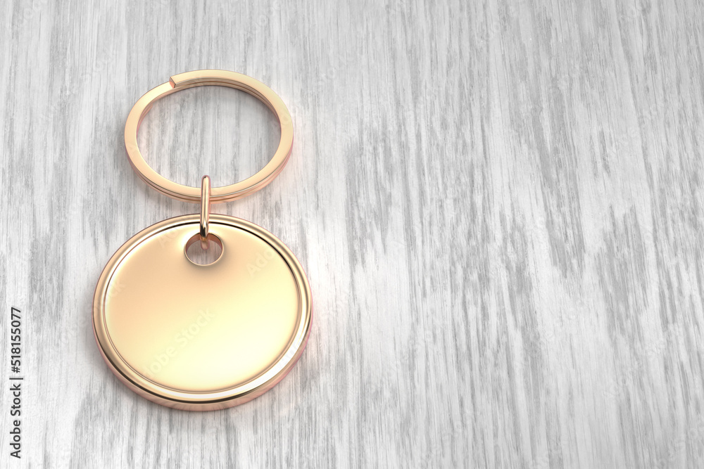 Rose gold round keychain on the wooden table Rose gold round keychain on the wooden table