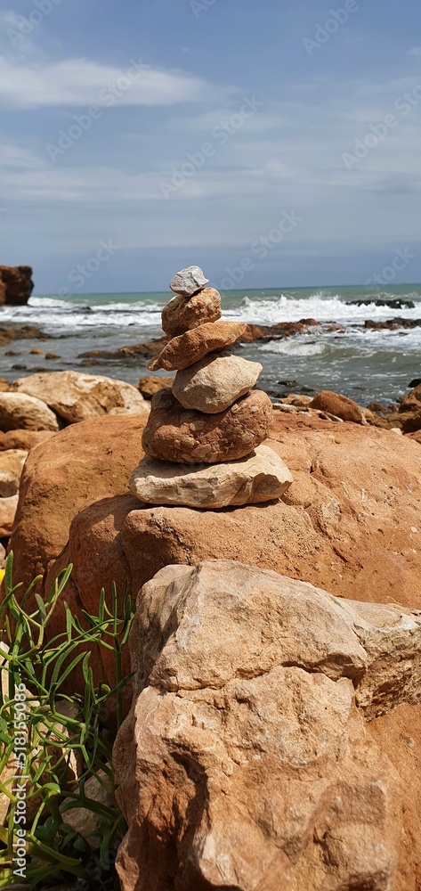 Tower of stones on the background of the sea. Stone tower balance.