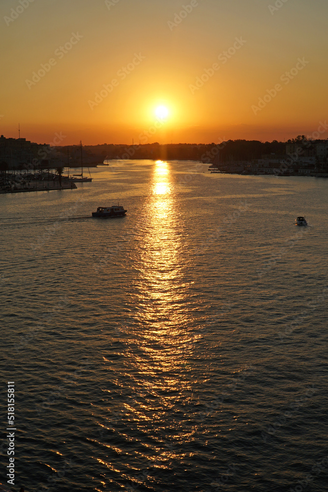 Sunset over Brindisi, Italy as seen from a cruise ship as it leaves port