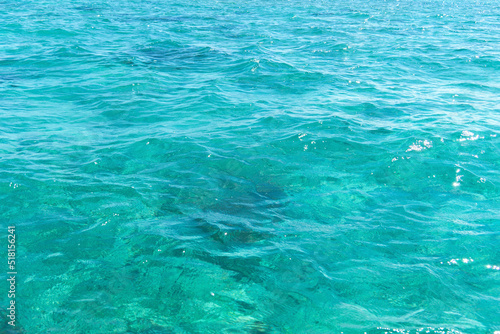 Blurred turquoise background of transparent sea water. Ripples on the water.