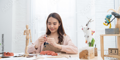 Young Asian girl making a sculpture with modeling clay at home .hobby clay sculpt concept photo