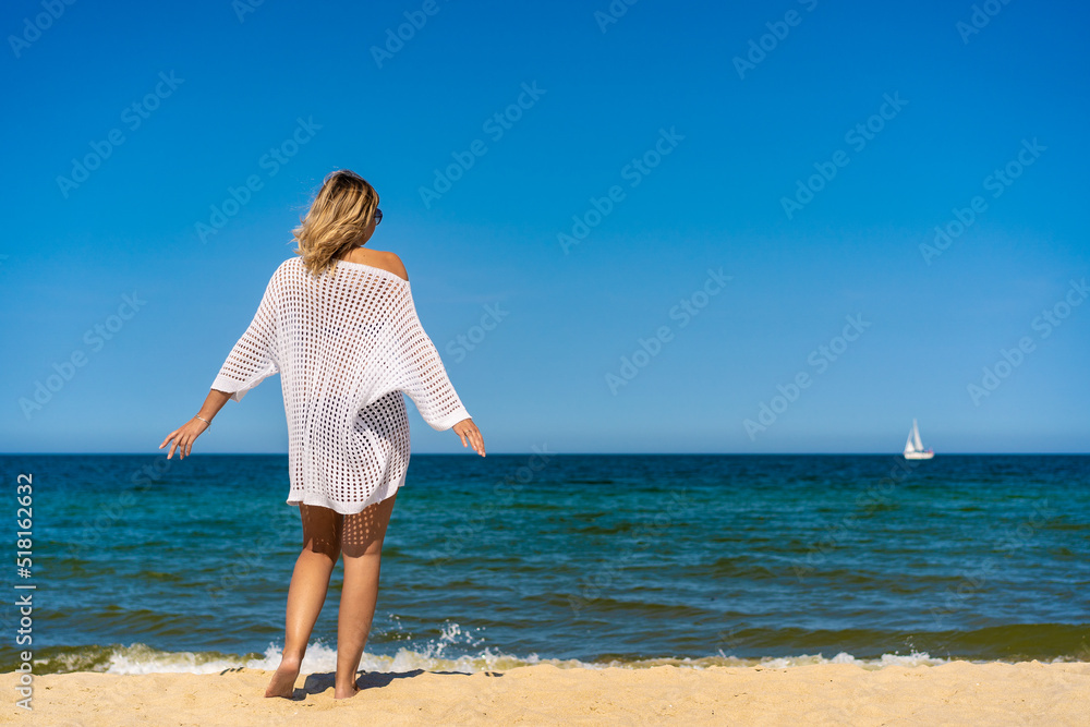 Woman walking on sunny beach