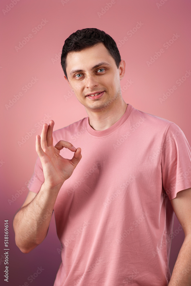 brunette man in t-shirt smiling and showing ok sign brunette man in t-shirt smiling and showing ok sign