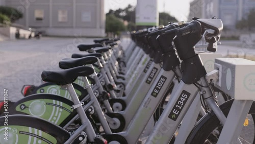 New bike sharing system along the streets of the city. Group of bikes ready to use. Bicycle rental service on city road. Public green transportation. Portugal, Lisboa. June 16, 2022.