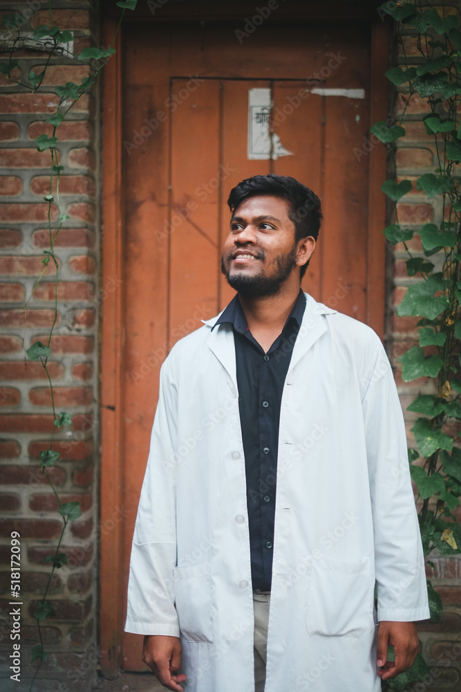 Fototapeta premium South asian young confident male doctor in white apron, Bangladeshi muslim medical student, protection from corona virus and flu viruses