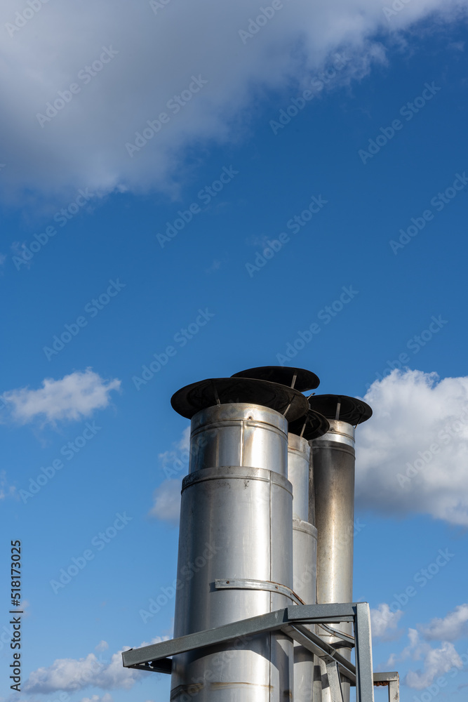 Side view of a Galvanized metal chimneys exhaust with a rain cap Side view of a Galvanized metal chimneys exhaust with a rain cap