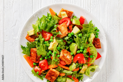 tofu salad with greens and vegetables on plate