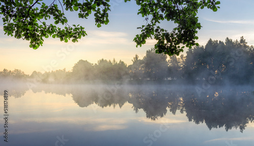 Morning landscape with fog and a pond. Dawn over the lake in the early morning.