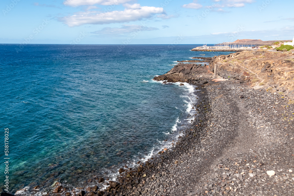 Panoramic view on a pebble stone beach Playa de San Blas near Los Abrigos, Tenerife, Canary Islands, Spain, Europe, EU. Coastline of the Atlantic Ocean. Crystal blue lagoon with no people. Vacation