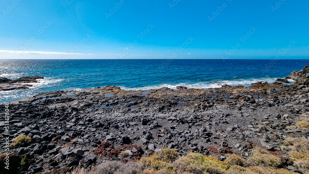 Panoramic view on black sand beach Playa de San Blas near Los Abrigos, Tenerife, Canary Islands, Spain, Europe, EU. Coastline of the Atlantic Ocean. Crystal blue lagoon with no people. Vacation