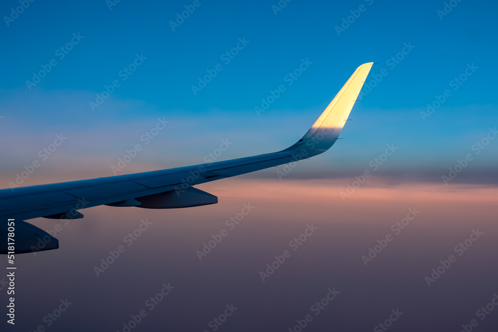 Sky and clouds sunset time at stratosphere from airplane window near the Canary Islands. Wing and engine of the aircraft can be seen. Abstract background. Romantic atmosphere above the clouds on board Sky and clouds sunset time at stratosphere from airplane window near the Canary Islands. Wing and engine of the aircraft can be seen. Abstract background. Romantic atmosphere above the clouds on board