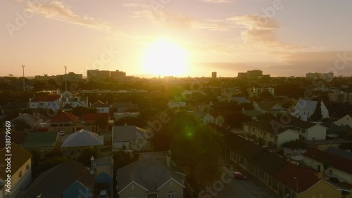 Forwards fly above residential development in urban neighbourhood. View against colourful sunset sky. Port Elisabeth, South Africa