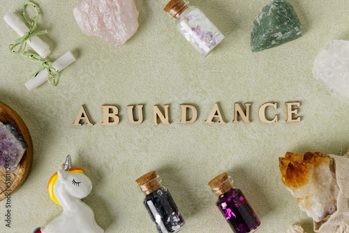 Foto Abundance word wooden letters with magic and happy objects, crystal stones