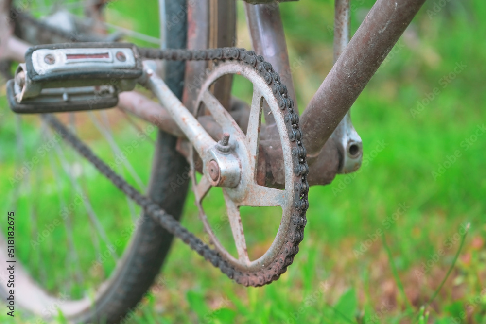 dirty chain, rusty pedal and crank arm of an old bicycle on background of grass closeup, vintage bicycle dirty chain, rusty pedal and crank arm of an old bicycle on background of grass closeup, vintage bicycle