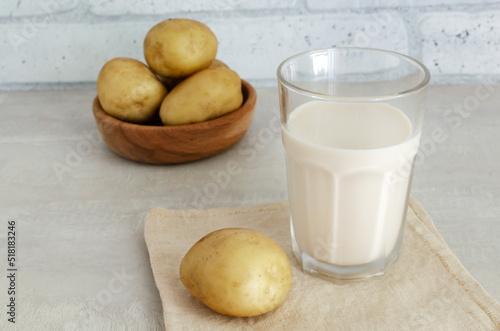 A transparent glass with potato milk on the table. A new trend in eating healthy. Alternative food concept. Vegetable Milk for Vegans. Horizontal orientation.