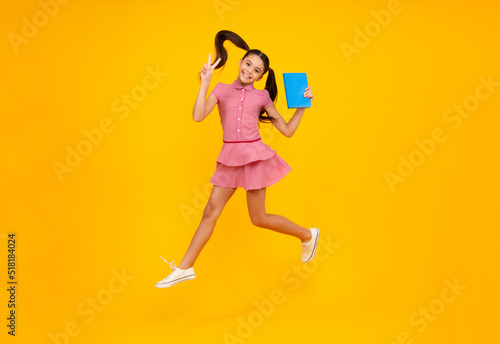 Teen girl pupil hold books, notebooks, isolated on yellow background, copy space. Back to school, teenage lifestyle, education and knowledge. Happy teenager, positive and smiling schoolgirl.