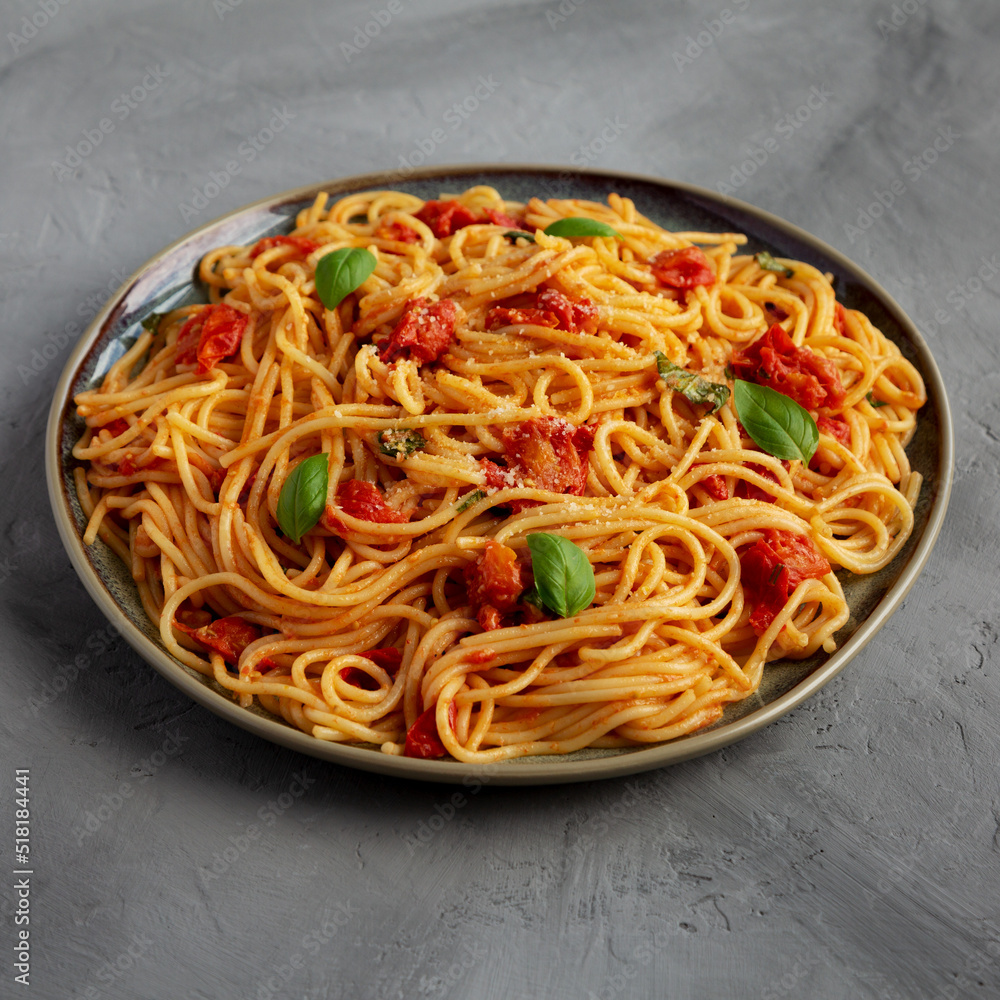 Homemade Spaghetti Pasta with Fresh Tomato Sauce on a Plate on a gray surface, side view. Homemade Spaghetti Pasta with Fresh Tomato Sauce on a Plate on a gray surface, side view.