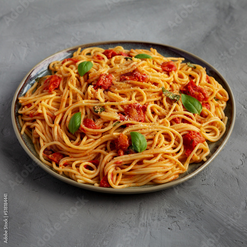 Homemade Spaghetti Pasta with Fresh Tomato Sauce on a Plate on a gray surface, side view.
