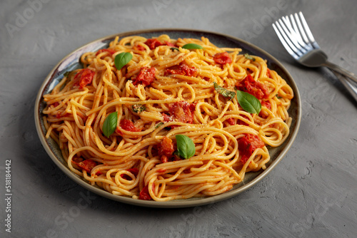 Homemade Spaghetti Pasta with Fresh Tomato Sauce on a Plate on a gray background, side view.