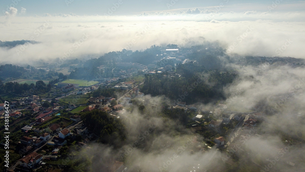 Vista de drone sobre campos no meio de neblina 