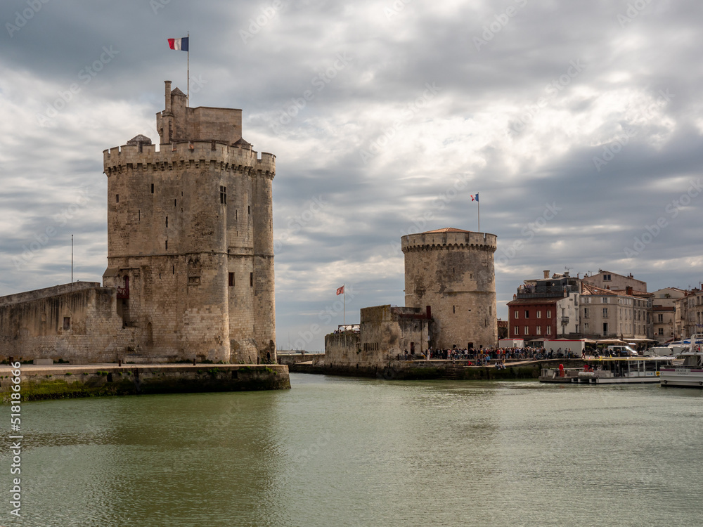 La Rochelle, France, July 2022. La Rochelle view of the two towers in the old port, beautiful architecture, blue sky next to the sailing boats standing in the port, free space