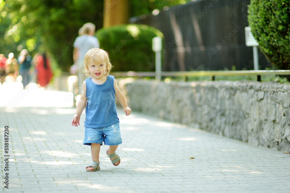 Funny toddler boy having fun outdoors on sunny summer day. Child exploring nature. Funny toddler boy having fun outdoors on sunny summer day. Child exploring nature.
