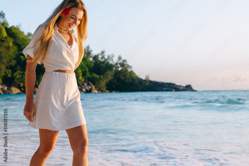 Happy carefree woman dancing at sunset on the beach. Happy free lifestyle concept.
