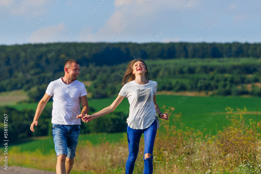 couple in casual clothes holding hands and running against fores couple in casual clothes holding hands and running against fores